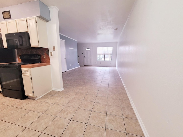 kitchen featuring tasteful backsplash, crown molding, black appliances, light tile patterned floors, and white cabinets