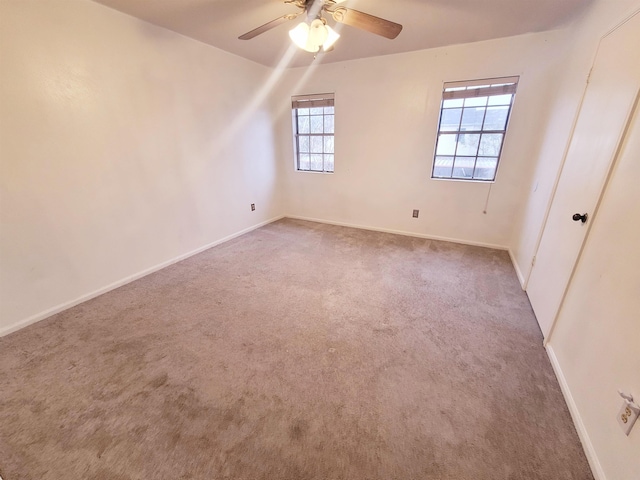 carpeted spare room featuring ceiling fan