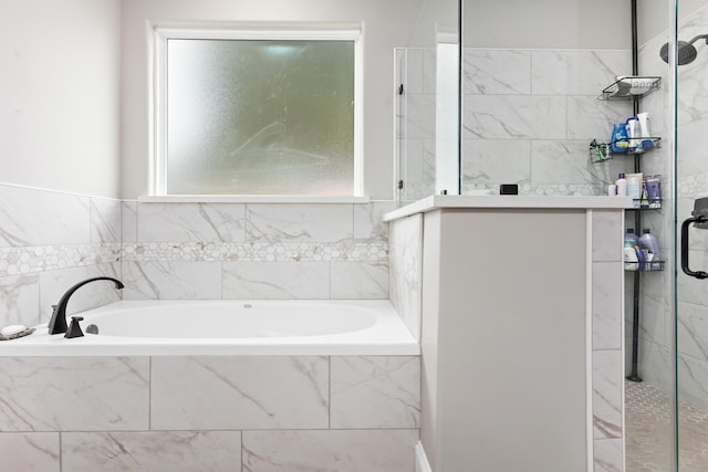 bathroom with plenty of natural light and separate shower and tub