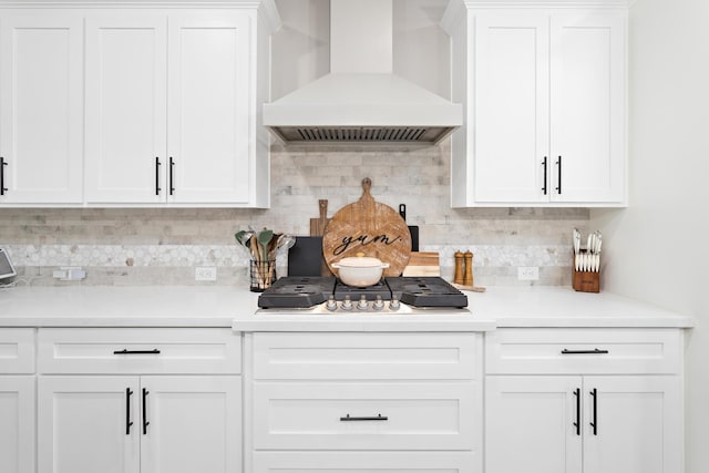 kitchen featuring premium range hood, white cabinets, and tasteful backsplash