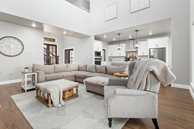 living room with a towering ceiling and dark hardwood / wood-style floors