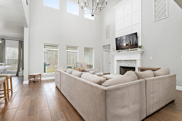 living room with a high ceiling, hardwood / wood-style floors, and a chandelier