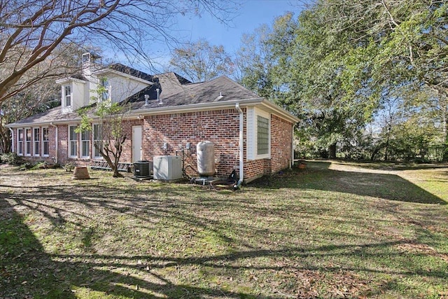 view of property exterior featuring central AC unit and a yard