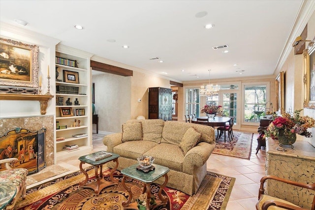 living room with built in features, crown molding, light tile patterned floors, and a chandelier