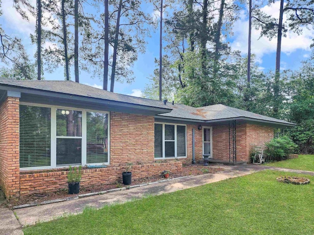 view of front of home with brick siding and a front lawn
