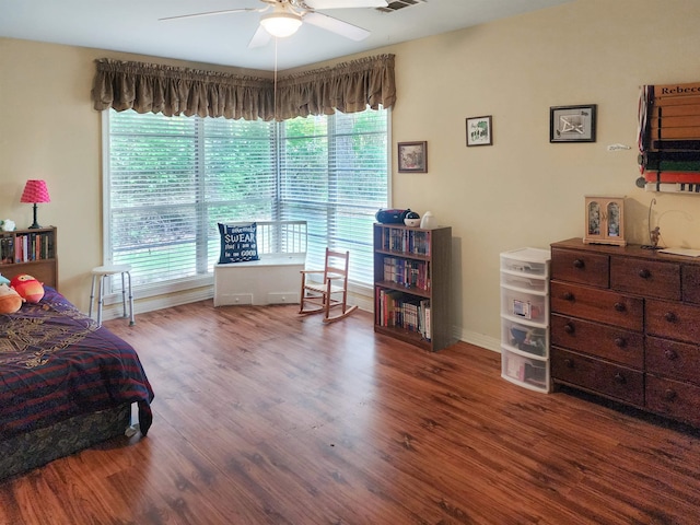 bedroom with baseboards, ceiling fan, wood finished floors, and visible vents