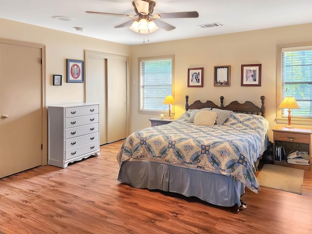 bedroom featuring visible vents, a ceiling fan, light wood finished floors, and a closet