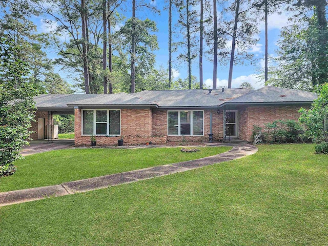 single story home featuring brick siding, a front yard, and an attached carport