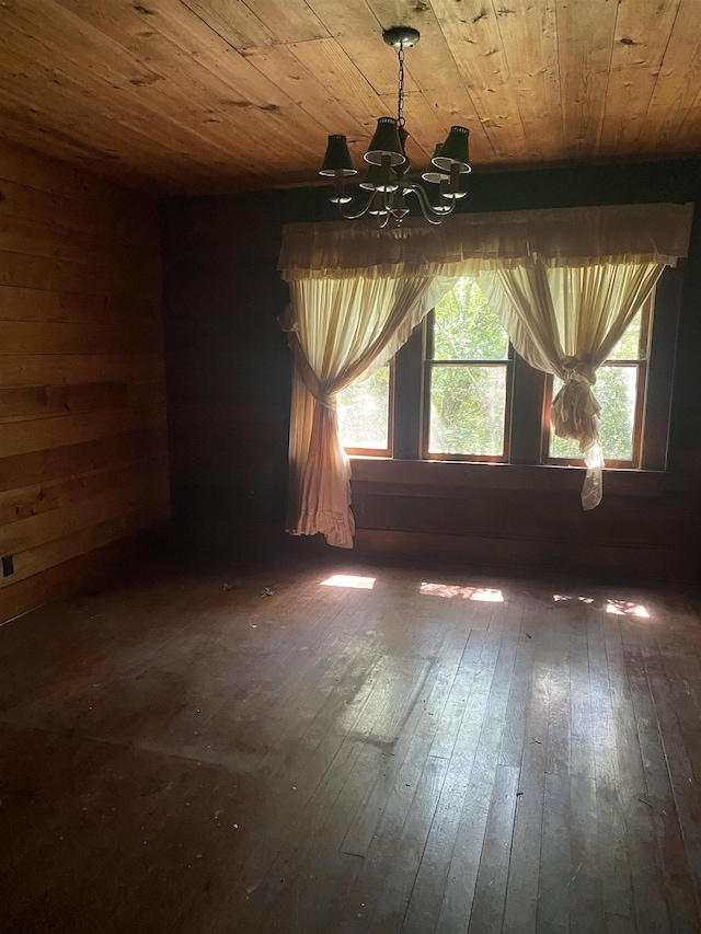 spare room with dark hardwood / wood-style floors, wood ceiling, and a chandelier