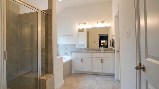 bathroom featuring tile patterned flooring, vanity, vaulted ceiling, and shower with separate bathtub