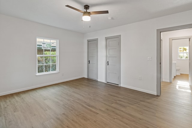 unfurnished bedroom featuring ensuite bath, ceiling fan, and light hardwood / wood-style floors