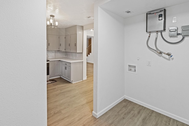 washroom featuring a notable chandelier and light hardwood / wood-style floors