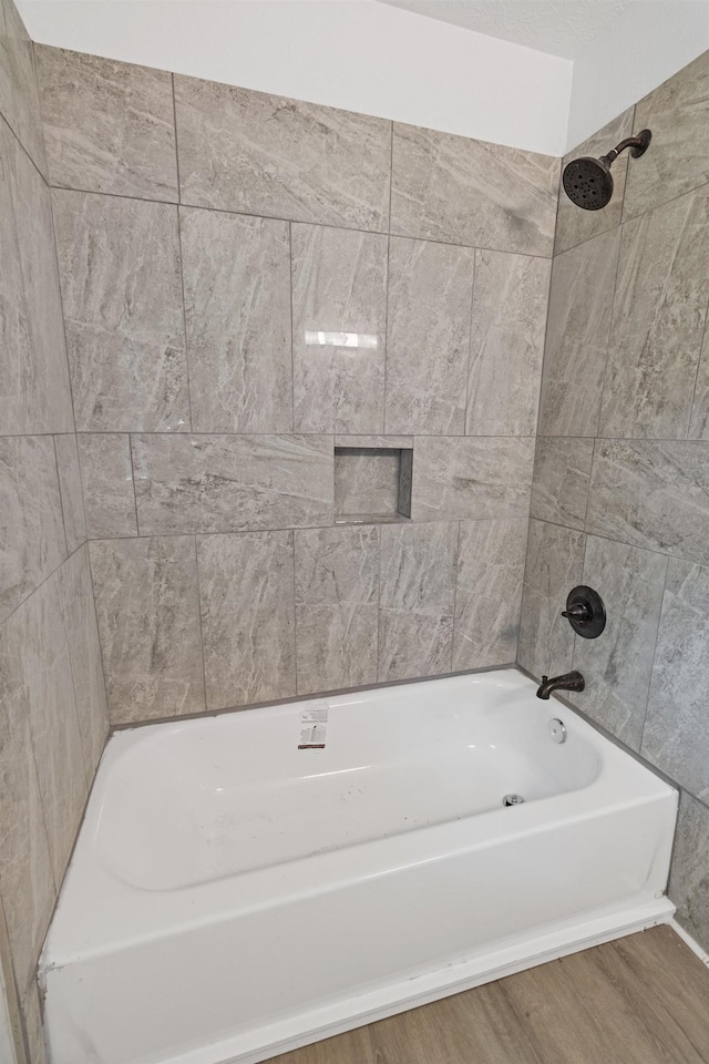 bathroom with hardwood / wood-style floors and tiled shower / bath combo