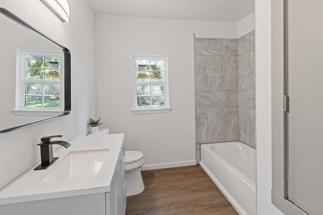 bathroom with toilet, plenty of natural light, vanity, and hardwood / wood-style flooring