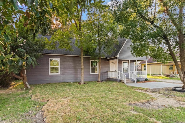 view of front of home with a porch, a shingled roof, and a front yard