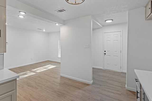 unfurnished living room featuring a textured ceiling and light wood-type flooring