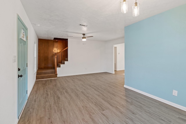 unfurnished living room with hardwood / wood-style floors, ceiling fan, and a textured ceiling