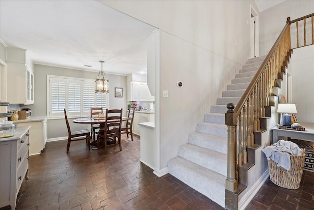 1550 Belvedere Dr, Beaumont, TX 77706 - staircase featuring a chandelier, brick floors, and baseboards