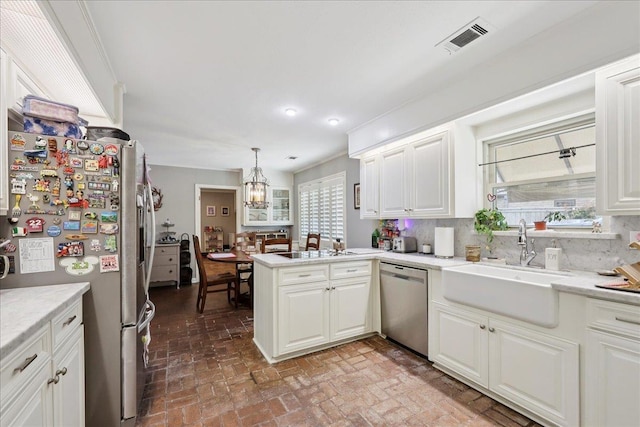 1550 Belvedere Dr, Beaumont, TX 77706 - kitchen featuring stainless steel appliances, brick floors, a sink, white cabinets, and backsplash