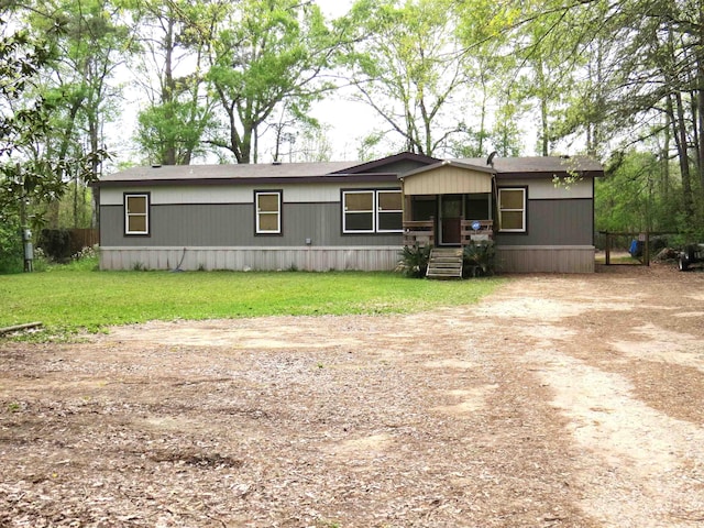 14547 Oak Leaf Loop, Splendora, TX 77372 - manufactured / mobile home with dirt driveway and a front lawn