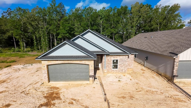 ranch-style house with an attached garage, a shingled roof, driveway, and brick siding