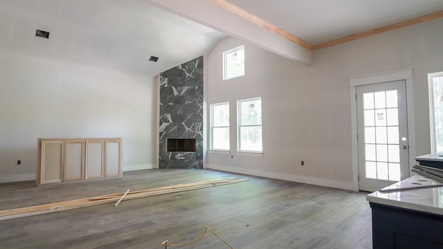 unfurnished living room with a fireplace, high vaulted ceiling, light wood-type flooring, and baseboards