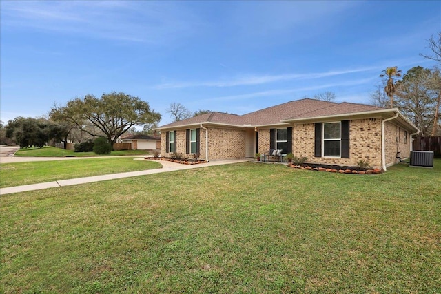 ranch-style home featuring a garage, a front yard, and central air condition unit