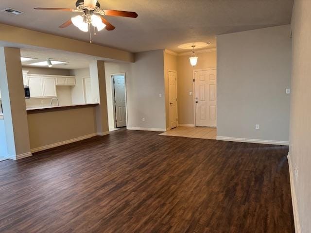 unfurnished living room with ceiling fan, sink, and dark wood-type flooring