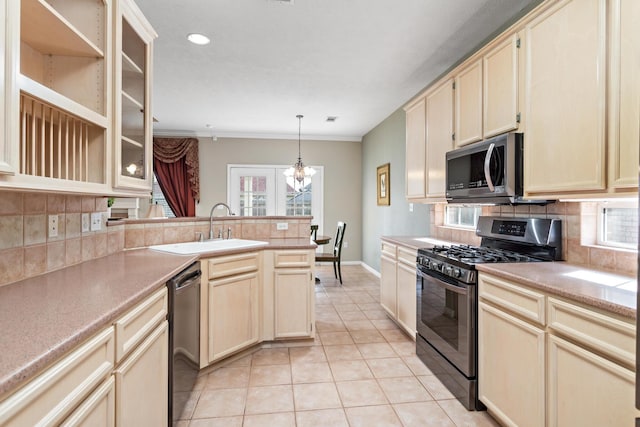 kitchen featuring sink, hanging light fixtures, light tile patterned floors, appliances with stainless steel finishes, and backsplash