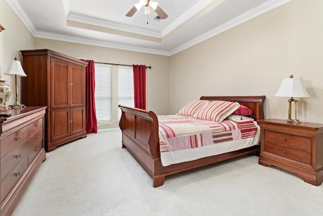 carpeted bedroom featuring crown molding, ceiling fan, and a raised ceiling