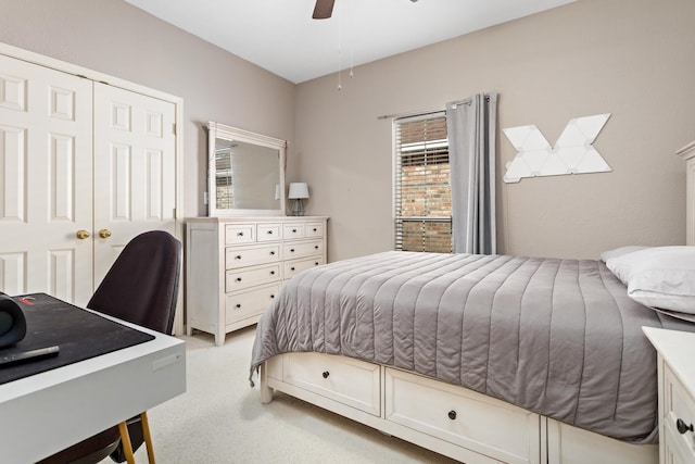 bedroom featuring light colored carpet, ceiling fan, and a closet