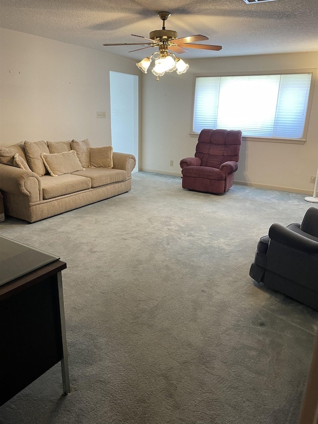 living area featuring a ceiling fan, baseboards, a textured ceiling, and carpet flooring