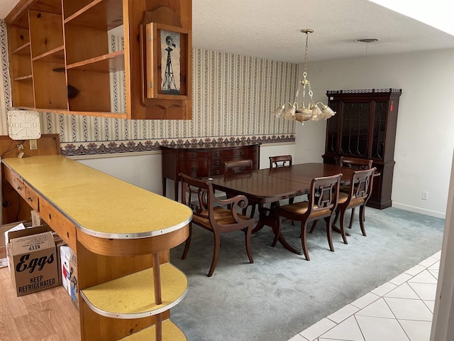 dining room featuring visible vents, baseboards, a chandelier, light colored carpet, and a textured ceiling