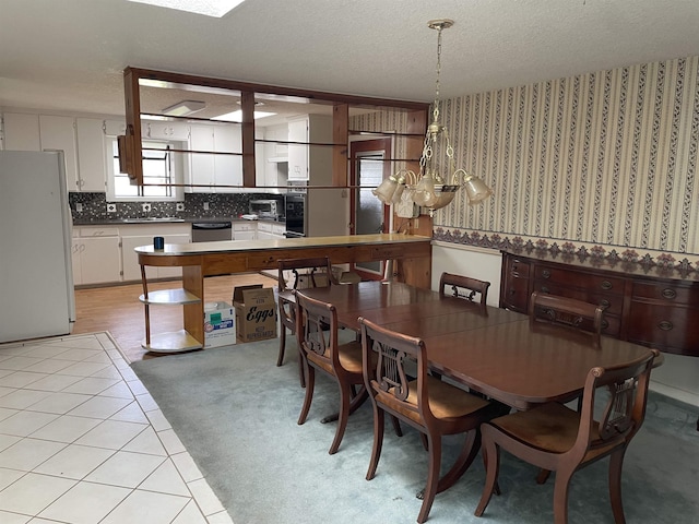 dining area with light carpet, a toaster, a textured ceiling, and wallpapered walls