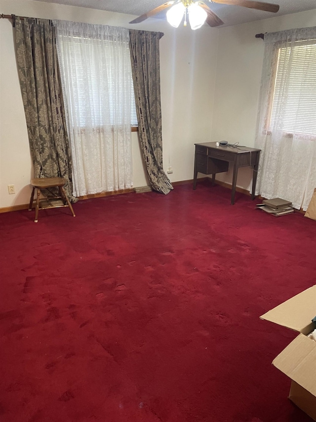 carpeted spare room featuring baseboards and ceiling fan