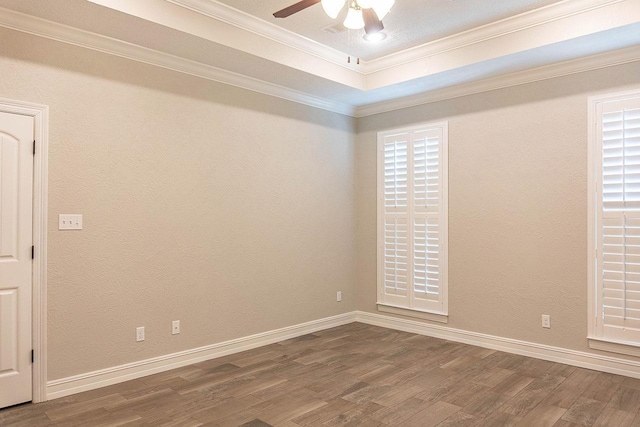 unfurnished room with a tray ceiling, crown molding, ceiling fan, and hardwood / wood-style flooring