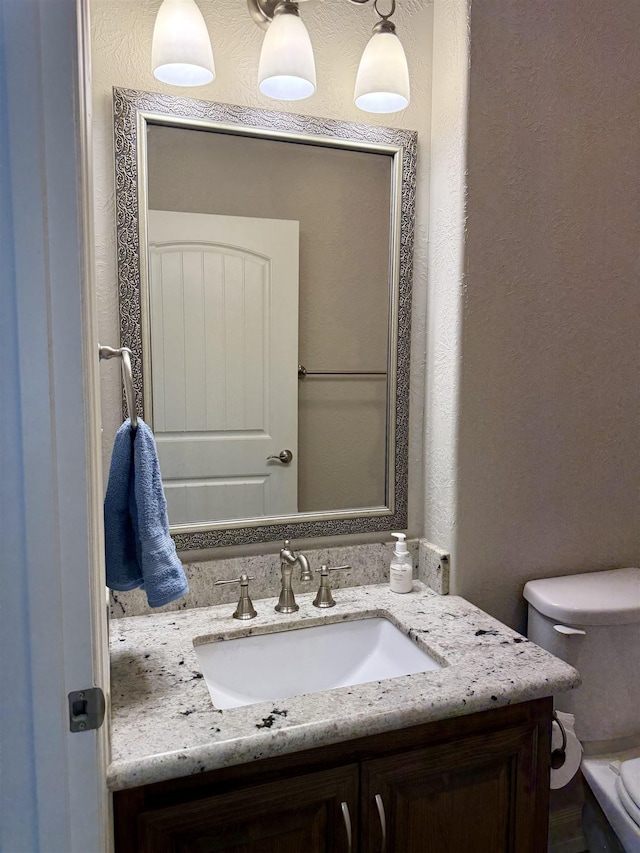 3865 E Pointe Dr, Beaumont, TX 77706 - half bath featuring vanity, toilet, and a textured wall