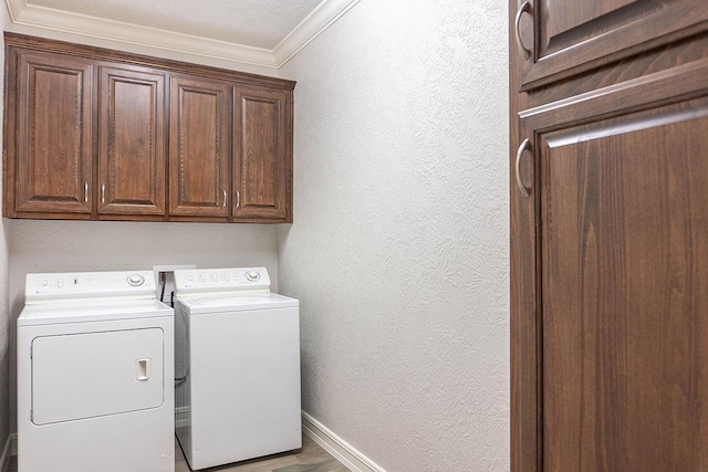 washroom with cabinets, a textured ceiling, crown molding, wood-type flooring, and independent washer and dryer