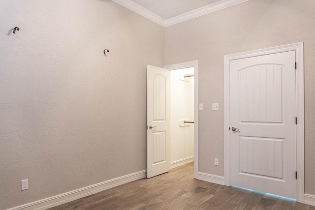 unfurnished bedroom featuring crown molding and hardwood / wood-style floors