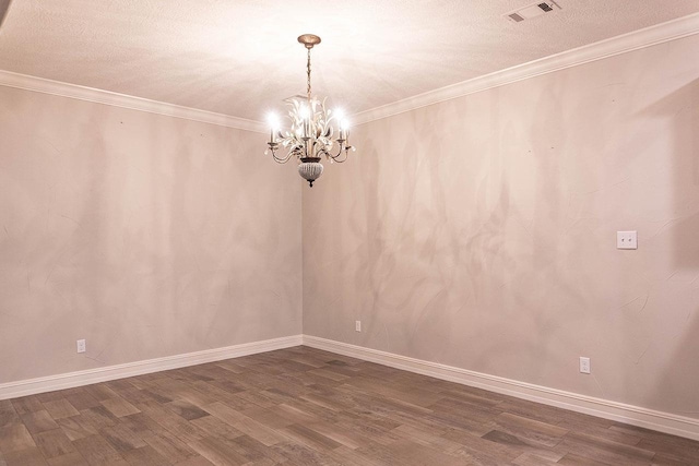 spare room featuring crown molding, dark wood-type flooring, a textured ceiling, and an inviting chandelier