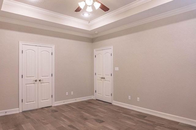 spare room featuring hardwood / wood-style flooring, ceiling fan, crown molding, and a tray ceiling