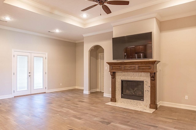 unfurnished living room featuring hardwood / wood-style flooring, ceiling fan, crown molding, and french doors