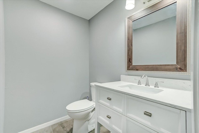 5960 Meadow Way, Beaumont, TX 77707 - half bathroom with baseboards, vanity, toilet, and wood finished floors