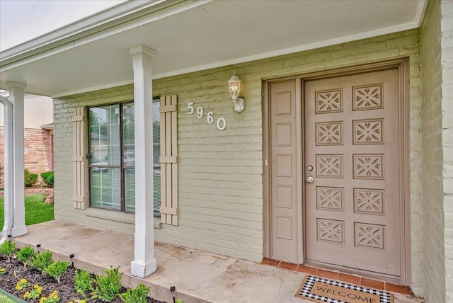 5960 Meadow Way, Beaumont, TX 77707 - doorway to property with covered porch and brick siding