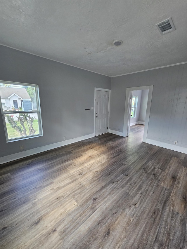 unfurnished room featuring dark wood-type flooring and a textured ceiling