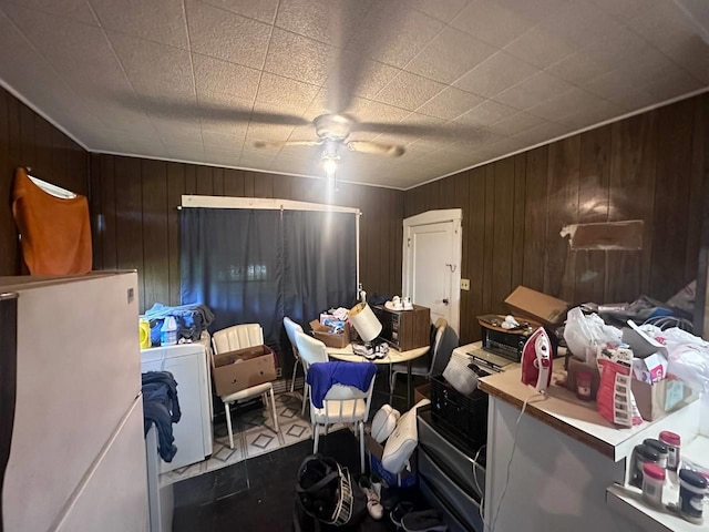 miscellaneous room featuring ceiling fan, washer / dryer, light tile patterned floors, and wooden walls