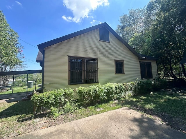 view of side of home with a yard and a carport