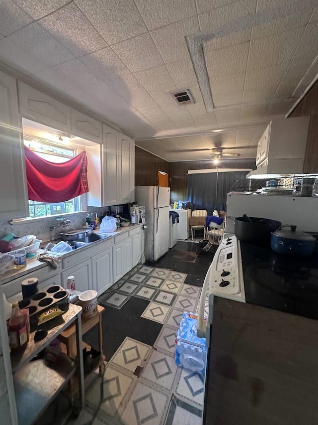 kitchen featuring white cabinets, white refrigerator, and sink