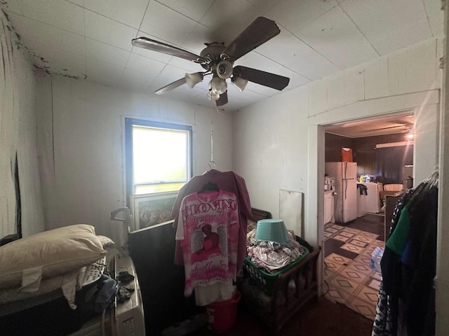 bedroom with ceiling fan and white fridge