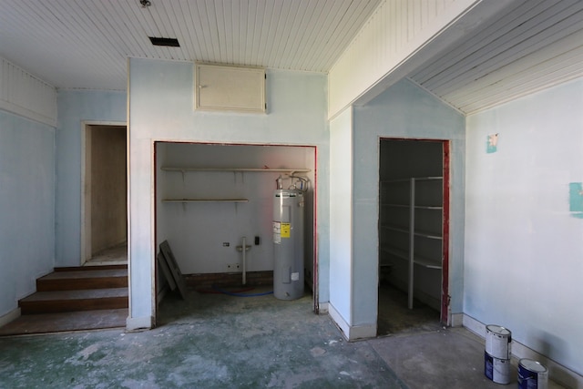stairway with water heater and concrete floors